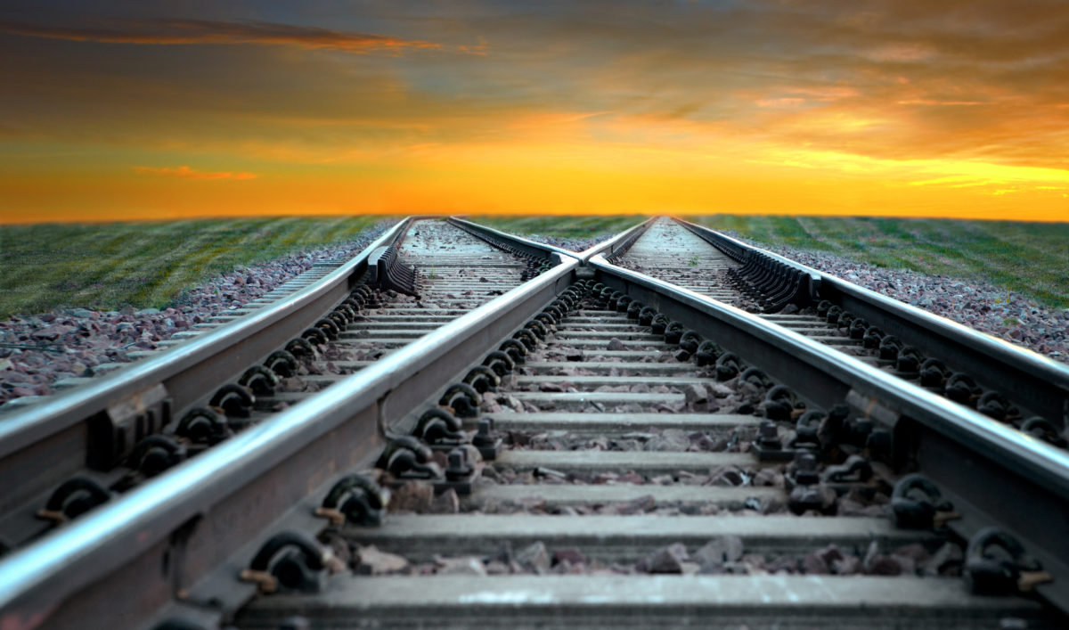 Landscape with railroad disappearing into sunset